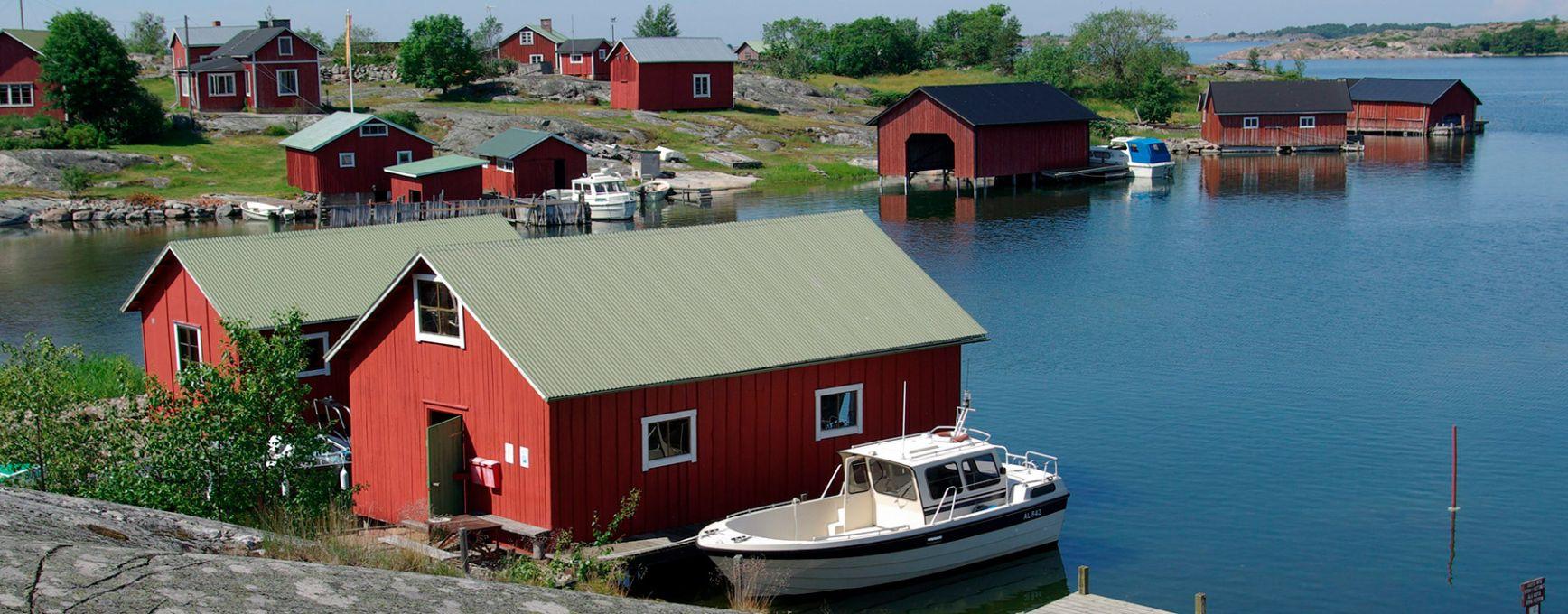 Red boathouses line the shore on an island in the Outer Archipelago.