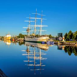Fartyg och tranor kantar Aura älv och markerar början på Åbo hamnområde.