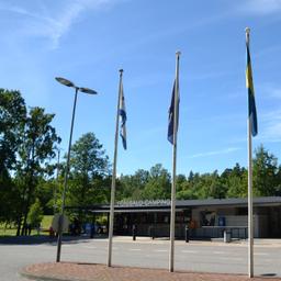 The reception building at Ruissalo Camping with four flags flying out the front.