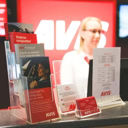 A salesperson behind the AVIS counter, where a variety of brochures have been placed.