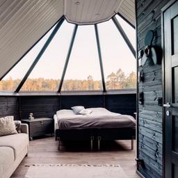 A star cottage at Tackork Gård & Marina, which features a double bed, sofa, and glass ceiling.